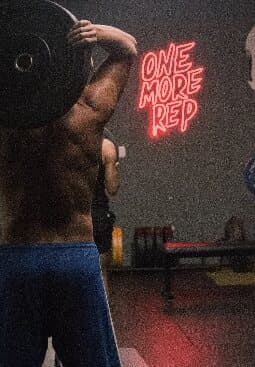 Athlete training beside the One More Rep sign